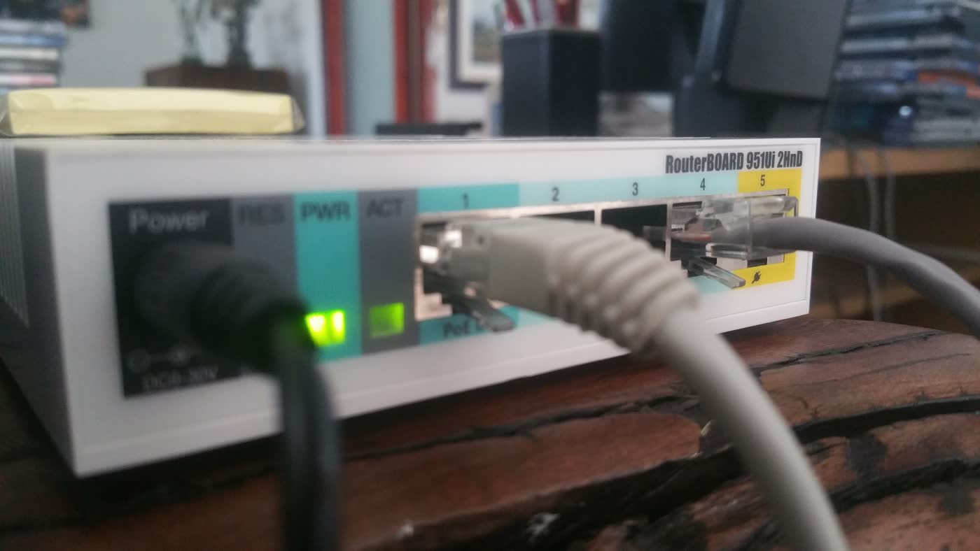 Close view of a MikroTik RouterBOARD 951Ui-2HnD with a connected Ethernet cable.