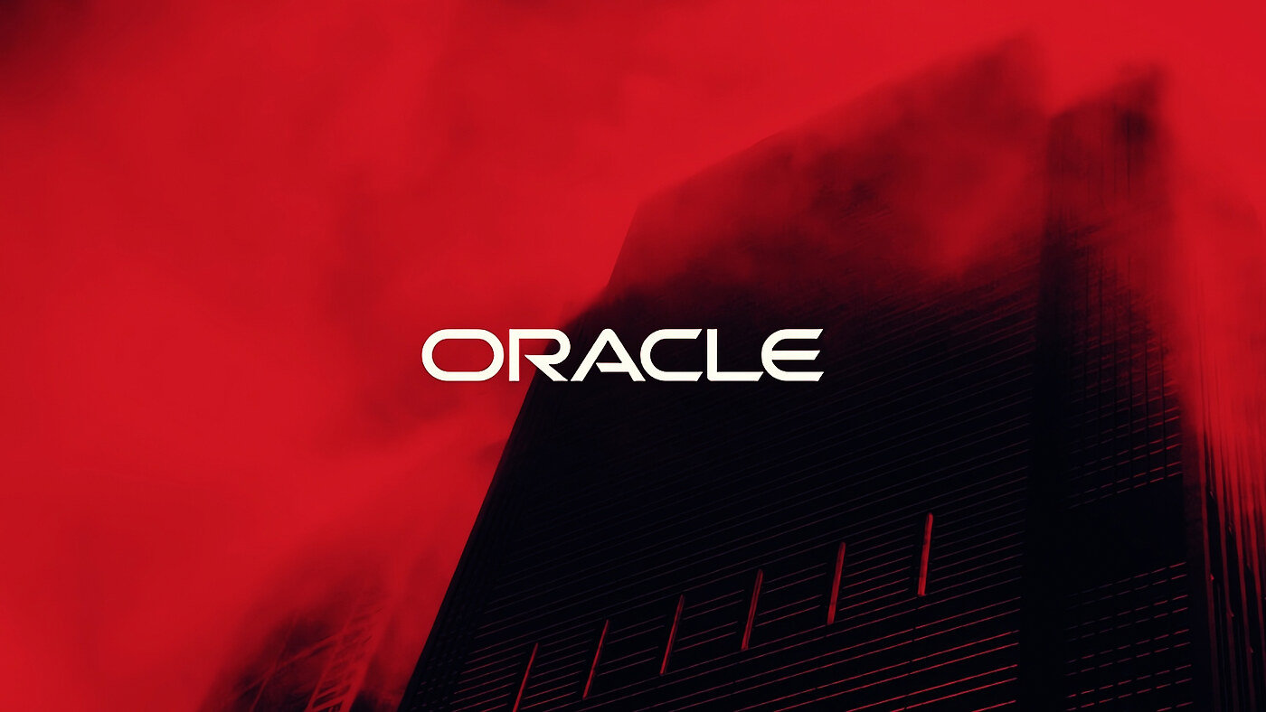 Oracle wordmark over a dark building and red sky.
